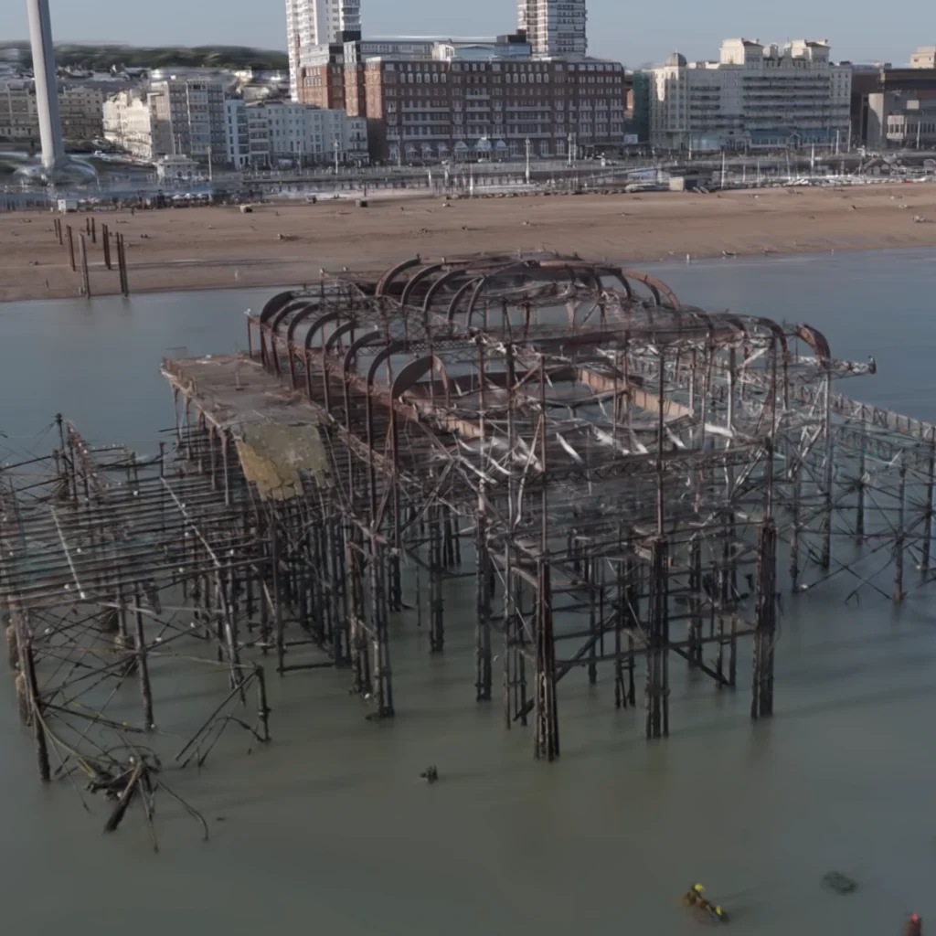Rekonstrukcja z lotu ptaka odsłoniętej konstrukcji West Pier w Brighton, z plażą i nabrzeżem w tle.