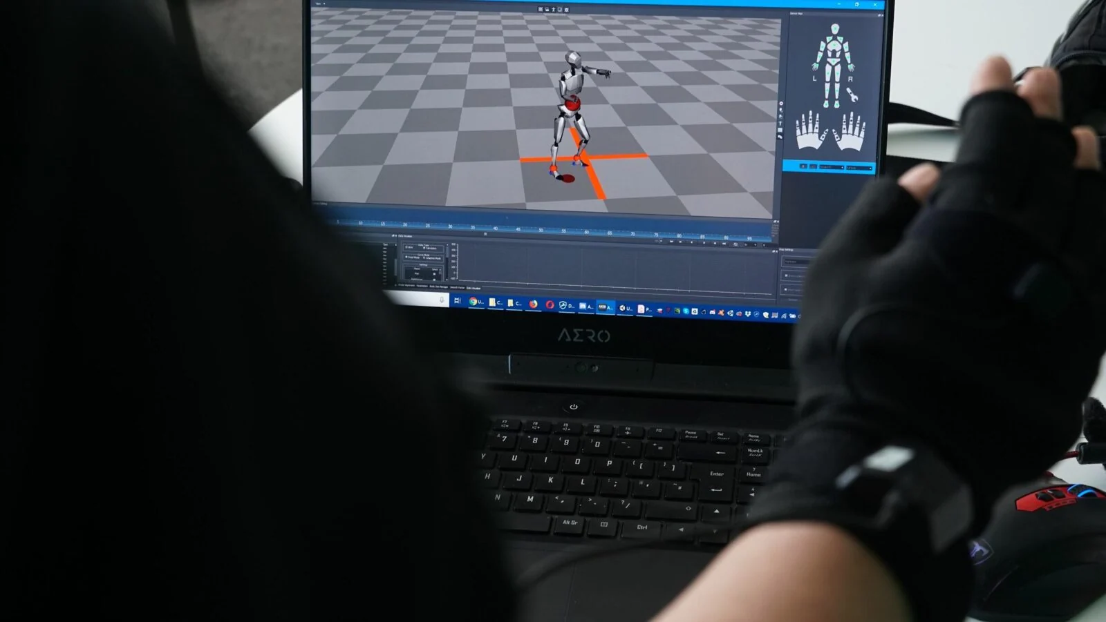Śledzona rękawica steruje cyfrową postacią na laptopie podczas prac nad motion capture.