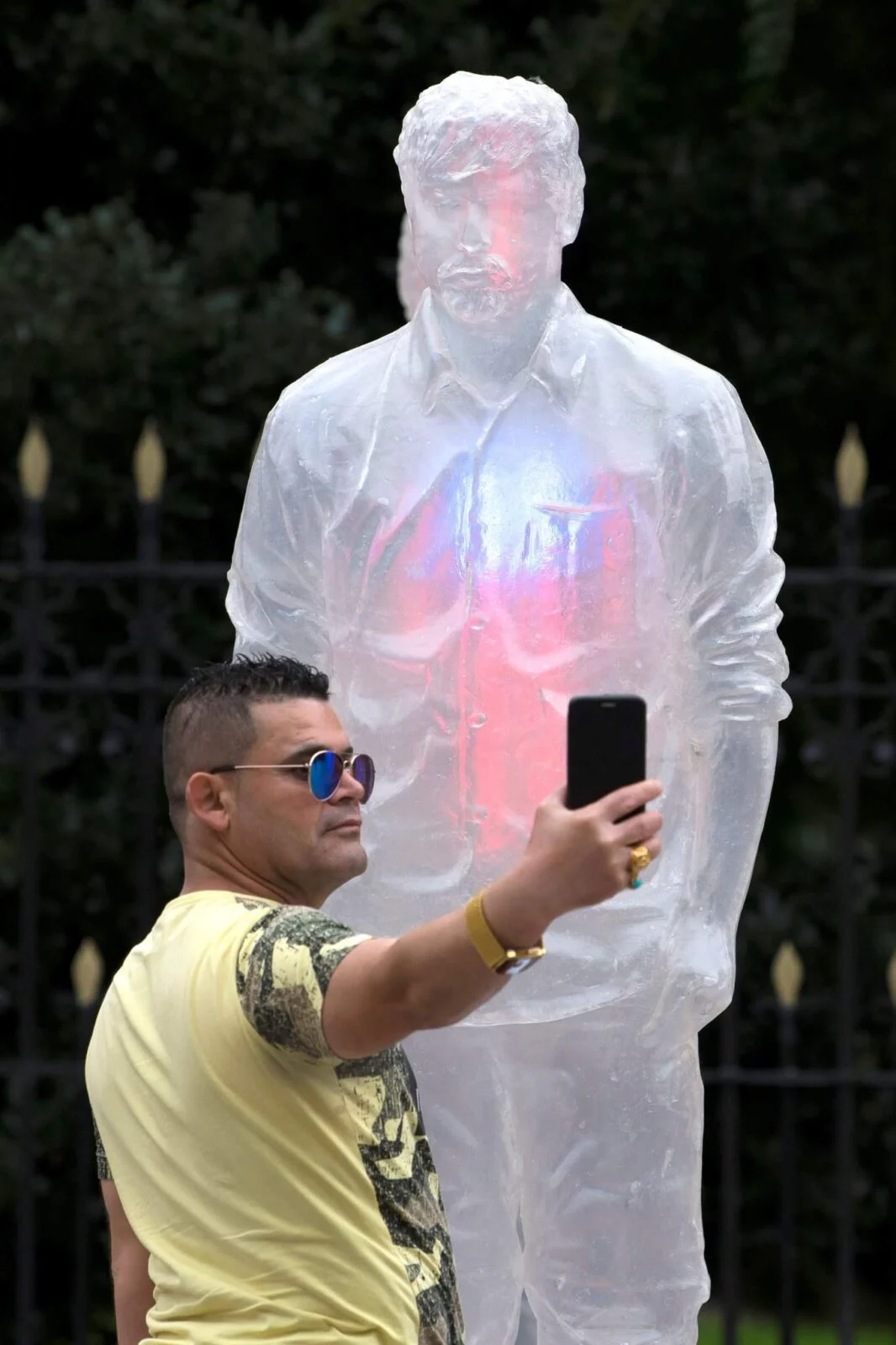 Zwiedzający robi selfie obok podświetlonej półprzezroczystej postaci w instalacji o nowotworach krwi.