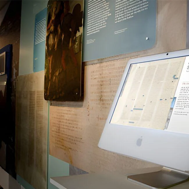 Interaktywna prezentacja Codex Sinaiticus na białym komputerze w galerii muzealnej.