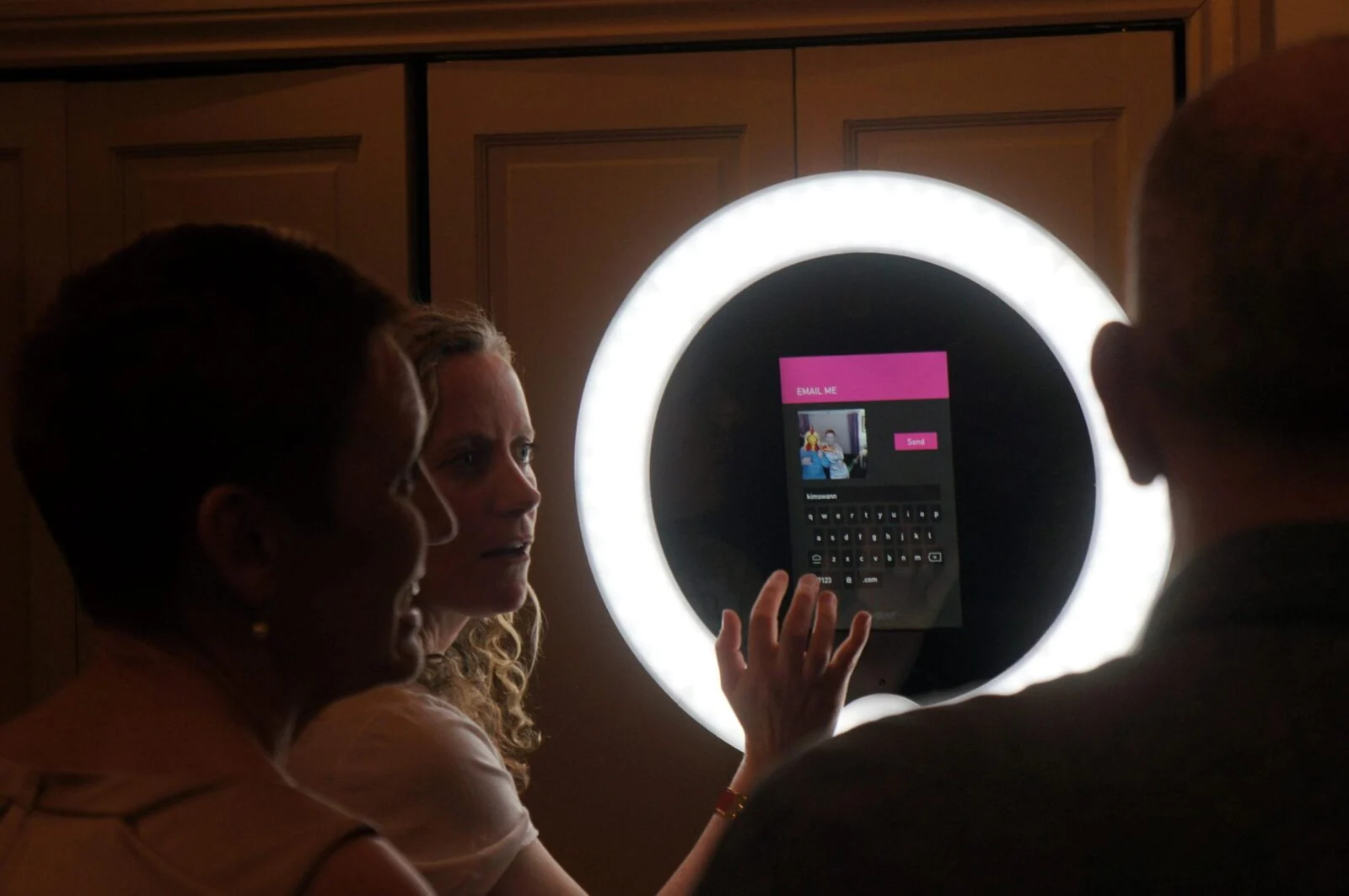 Goście korzystają z kiosku fotograficznego Gifstar otoczonego jasnym pierścieniem światła.
