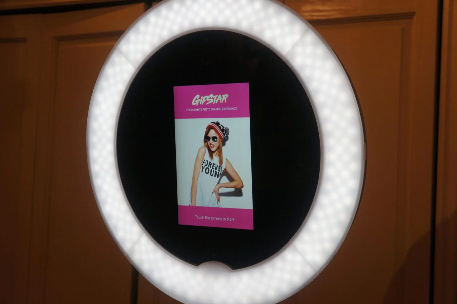 Ekran dotykowy Gifstar pokazuje portret wewnątrz podświetlonego pierścienia kiosku.