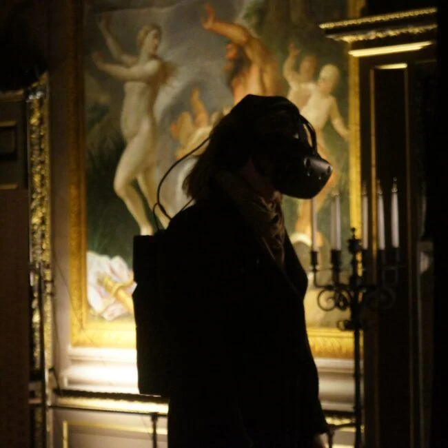 Zwiedzający w goglach VR w bogato zdobionym historycznym wnętrzu podczas Pleasure Palace.