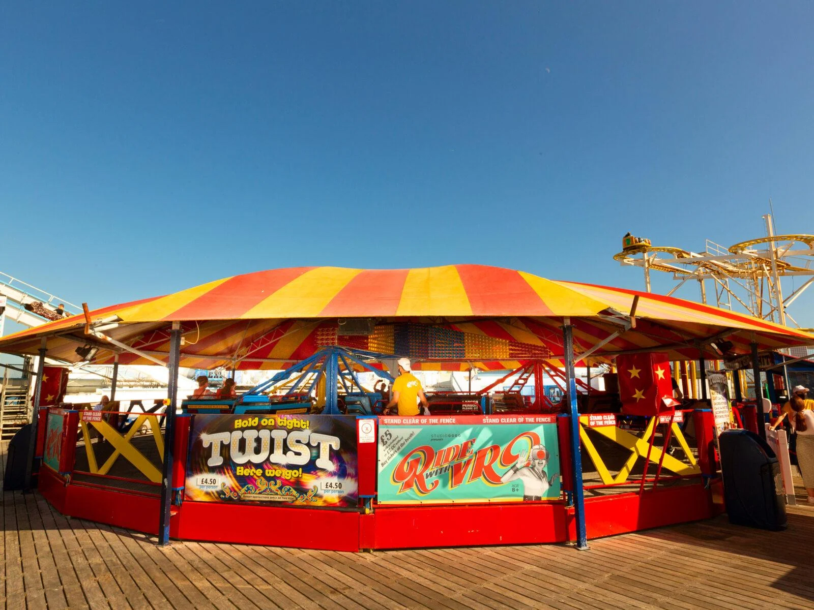 Karuzela Twister pod czerwono-żółtym zadaszeniem na molo w Brighton.