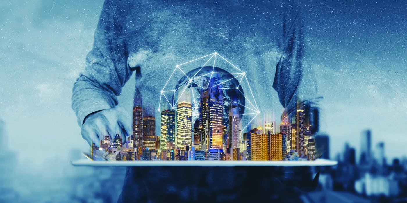 Cyfrowa panorama miasta unosi się nad tabletem z geometrycznym globem sieciowym.