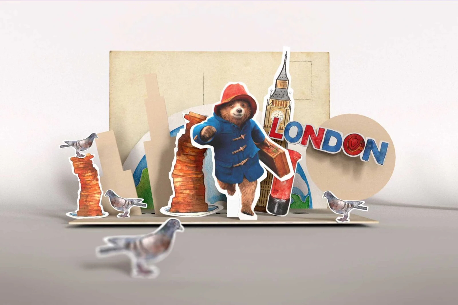 Paddington z walizką w rozkładanej scenie Londynu z gołębiami i Big Benem.